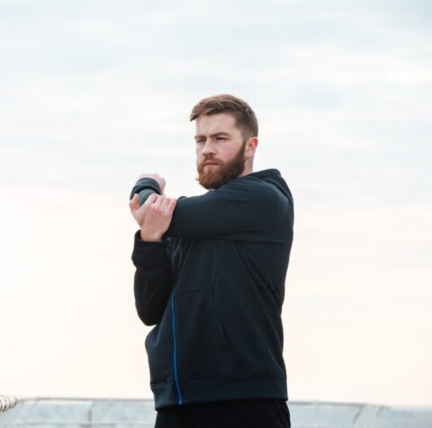 A fit man pauses mid-stretch during his workout, reflecting on his body composition goals after an InBody scan at Gameday Men’s Health in Raleigh.