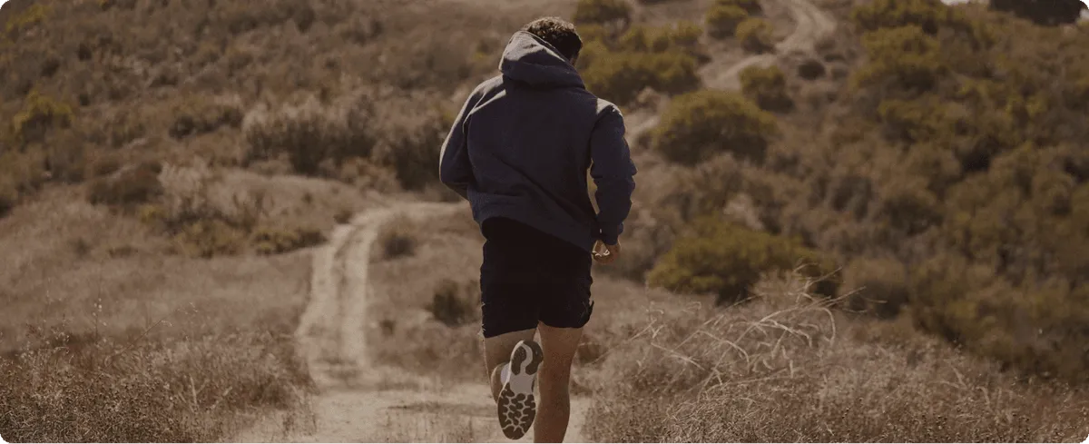 Man running outdoors in the mountains, illustrating taking action, consulting a specialist, and beginning a personalized journey toward optimal men’s health and sexual wellness.