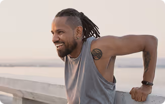 Fit man working out near the ocean, symbolizing the strength and vitality supported by anti-aging and longevity treatments.
