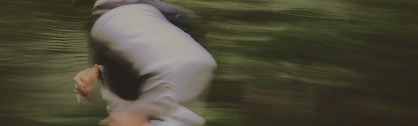 Runner training on a forest path surrounded by nature, reflecting the focus on physical wellness and balance encouraged at Gameday.
