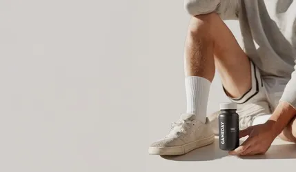 Fit man holding a Clomid pill bottle, highlighting treatment options for boosting testosterone and supporting men’s wellness.