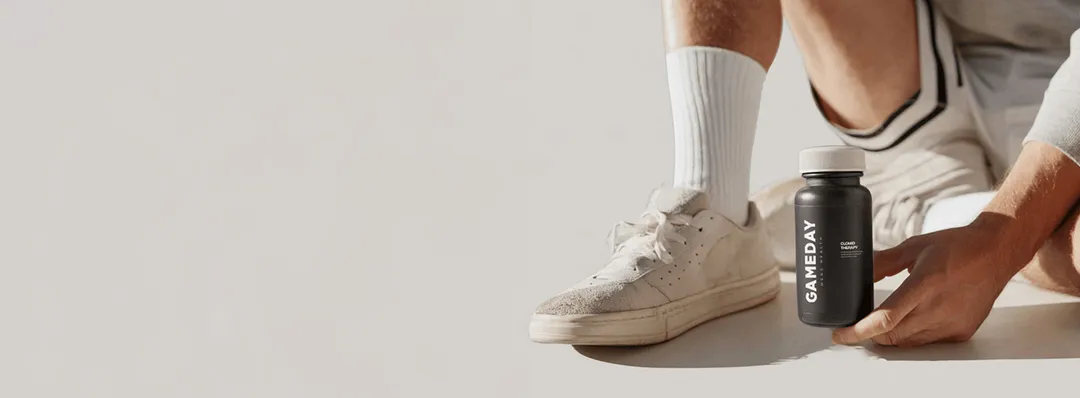 Fit man dressed in sportswear displaying a prescription bottle used for Clomid therapy as part of men’s hormone optimization programs.