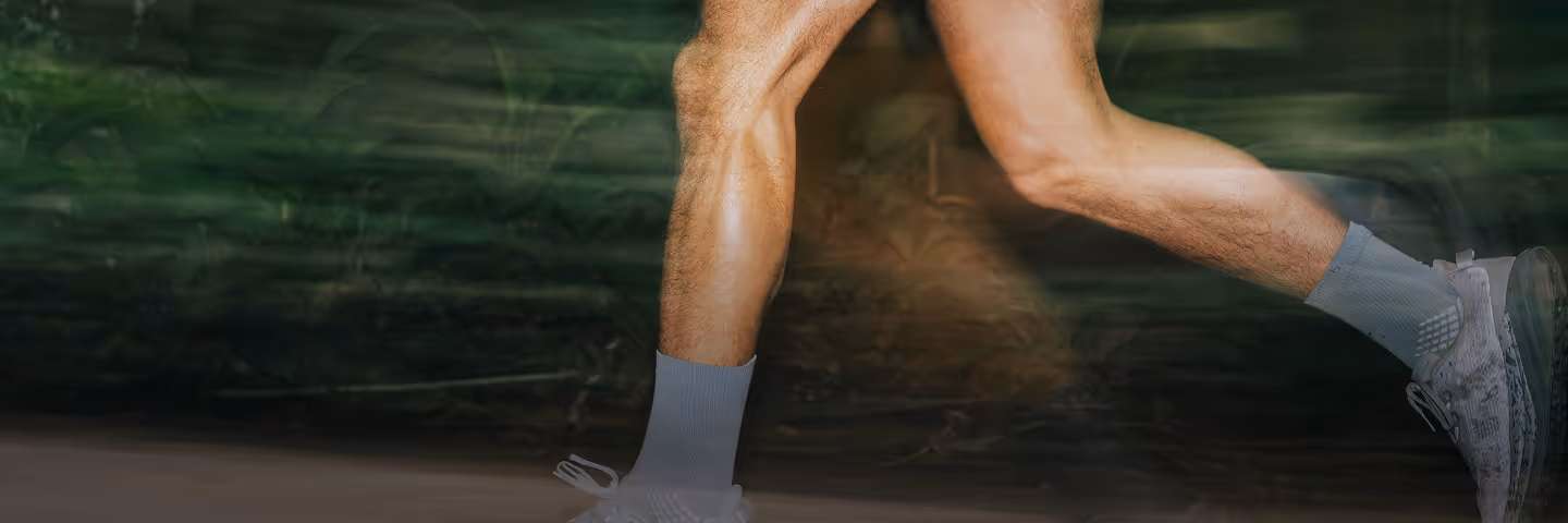 Athletic male runner navigating a forest trail, symbolizing physical strength, cardiovascular health, and active wellness habits.