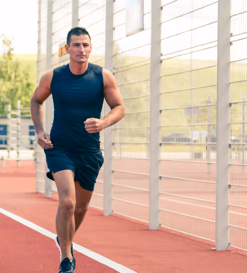 A man sprinting on a track, illustrating the benefits of Shockwave Therapy for sports injuries and rehabilitation. 