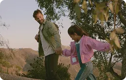 Man hiking in the mountains with his daughter, representing long-term health goals supported by Gameday Men’s Health services.