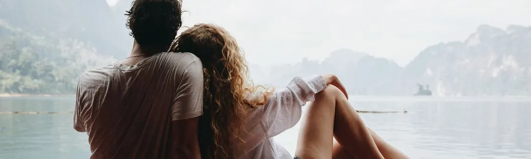 Young couple looking out over foggy lake.