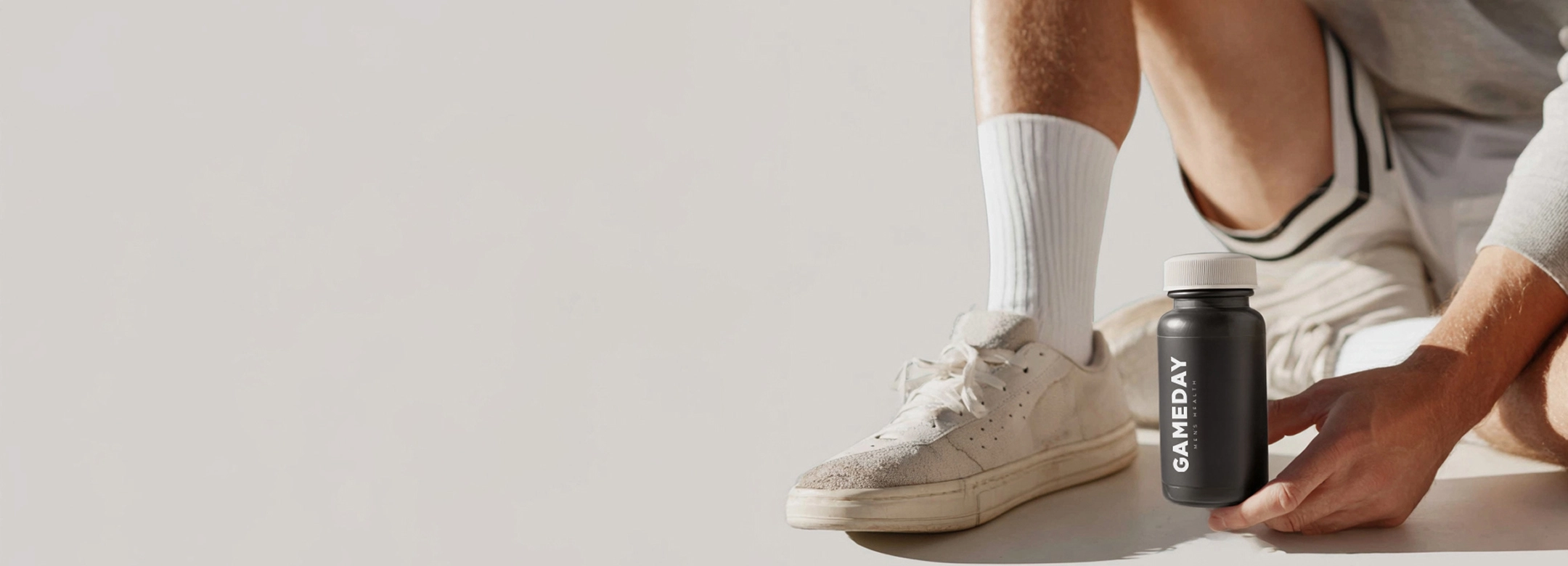 Fit man holding a Gameday Men's Health bottle, highlighting treatment options for boosting testosterone and supporting men’s wellness.