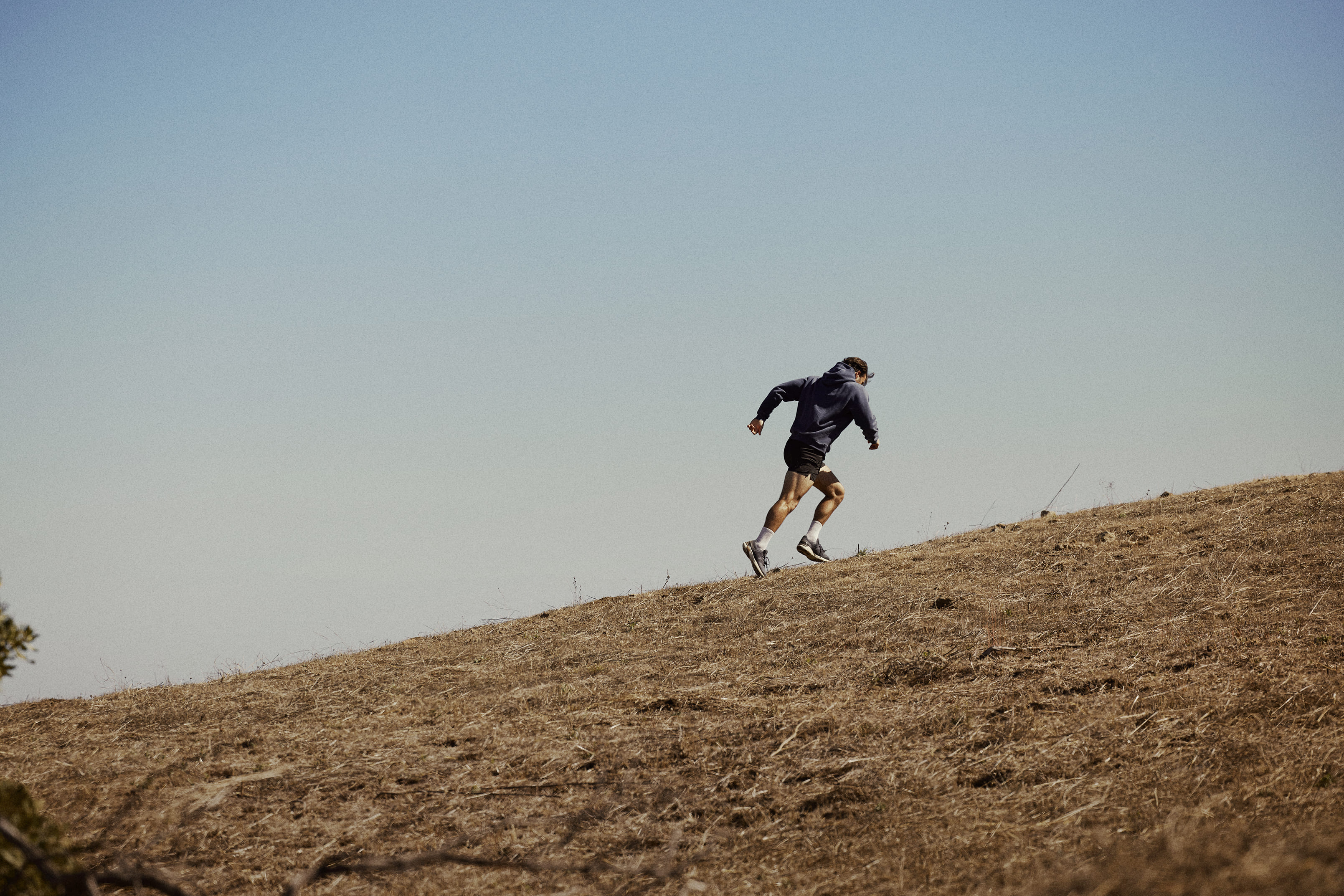 A person running uphill outdoors, embodying energy, strength, and an active lifestyle.