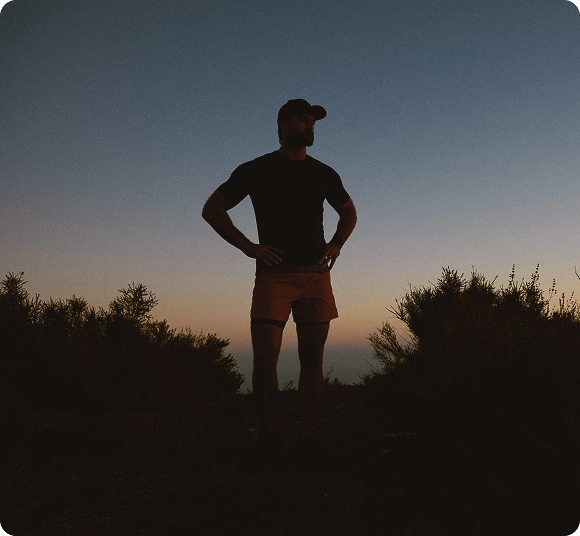 Fit man standing at sunset after a challenging run, representing the strength, energy, and vitality supported by Gameday Men’s Health.