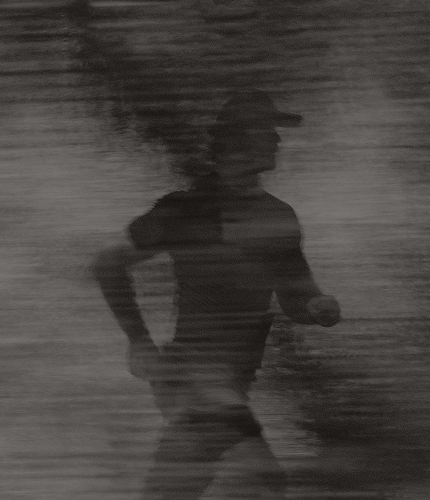 Man running through a forested trail, symbolizing overall performance, recovery, and wellness supported by comprehensive men’s health services at Gameday Men’s Health in Syracuse, NY.