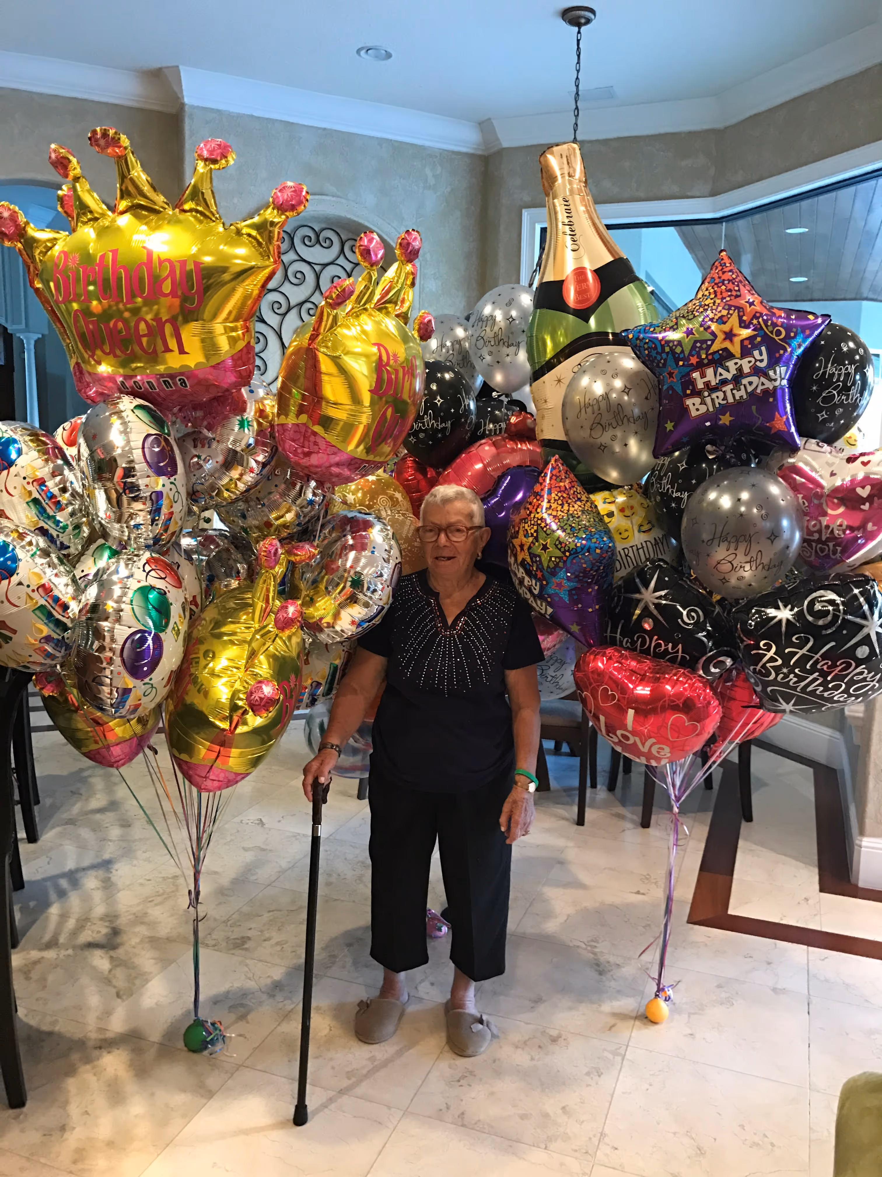 a woman standing next to a bunch of balloons