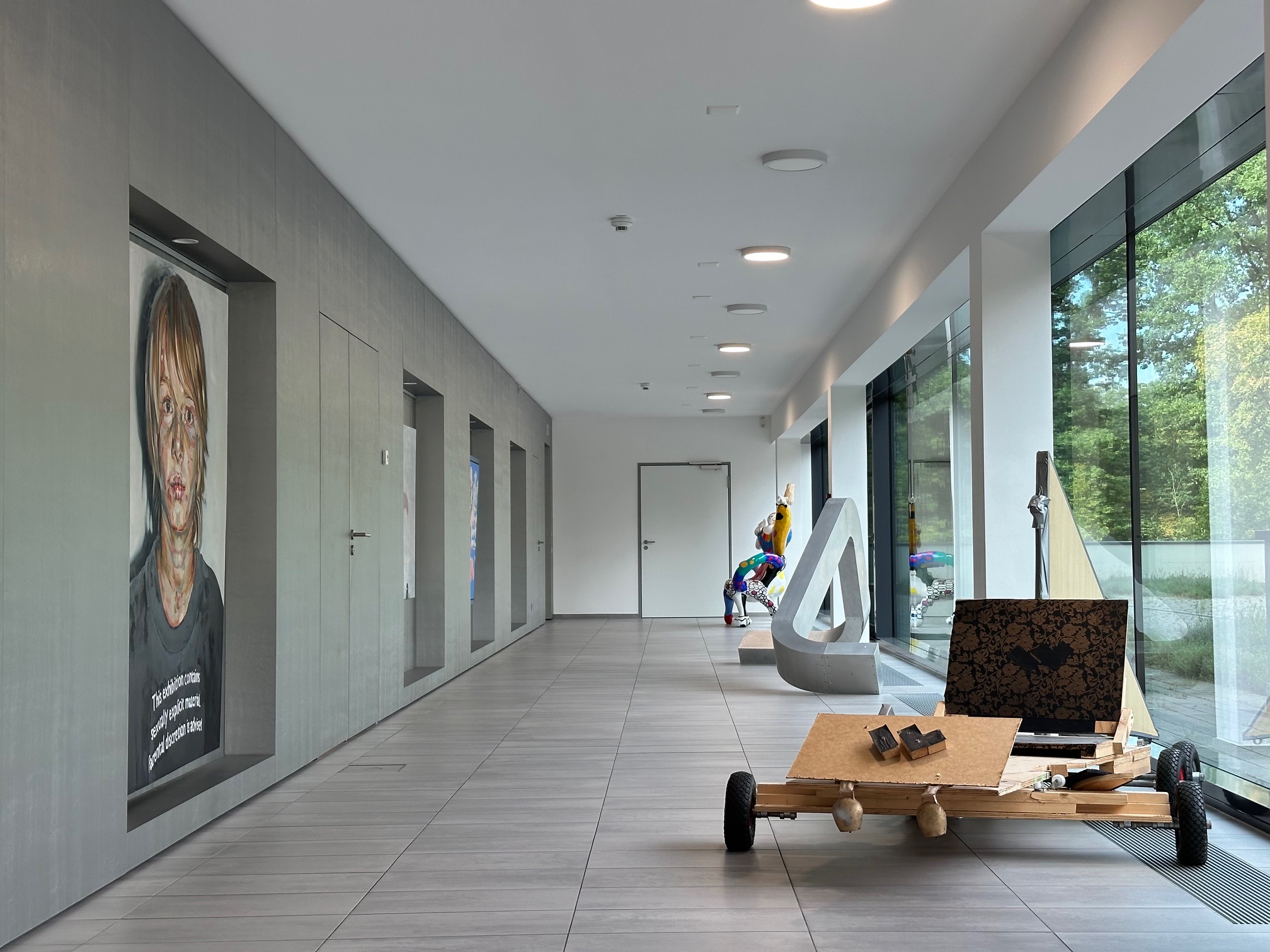 WEFRA Eingangsbereich: Moderner heller Flur mit großen Fenstern, abstrakten Skulpturen und Kunst-Objekten.