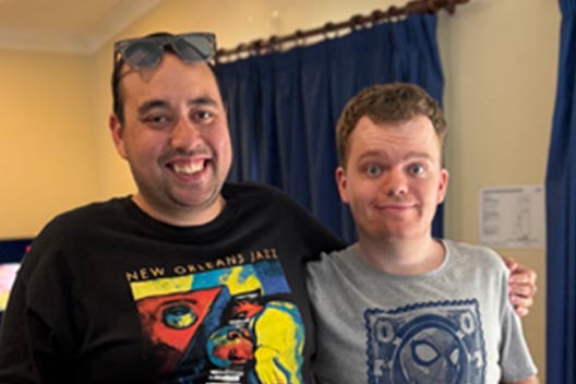 Two men smiling in a close-up indoor shot