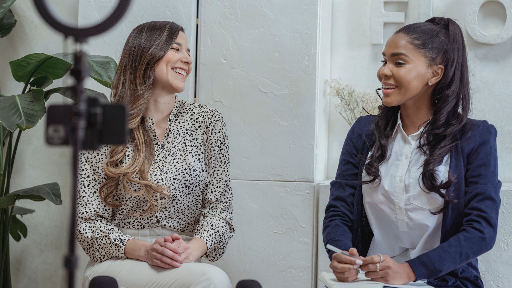 Two people recording a daylight testimonial interview in a bright interior location