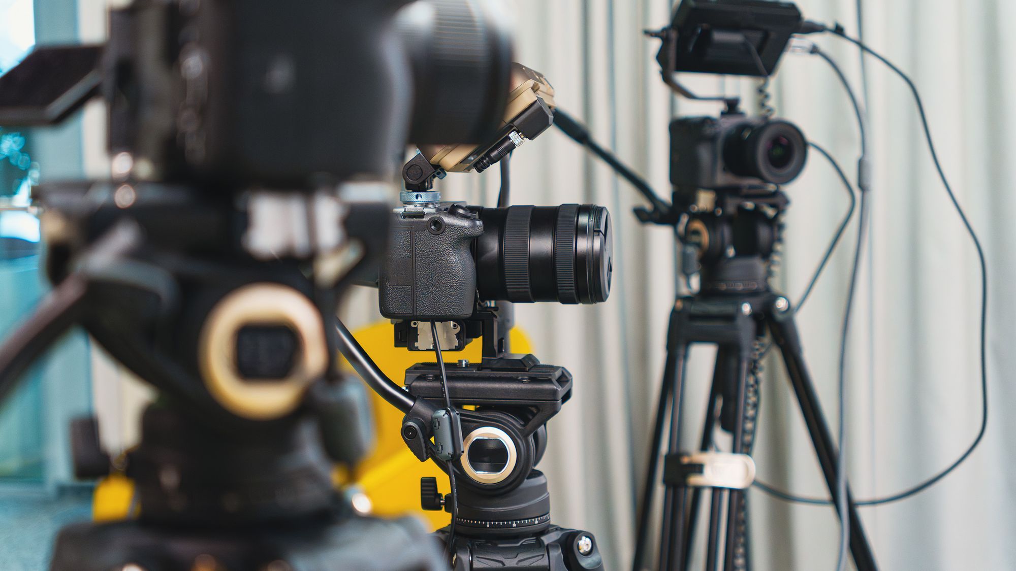 Two cameras on tripods set up with production gear before a corporate video shoot