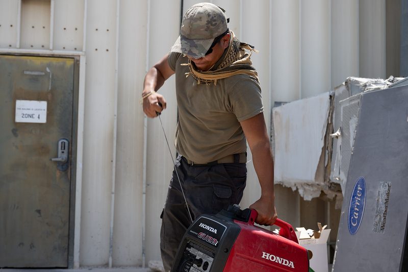 HVAC technicians in uniform servicing air conditioning equipment on the job