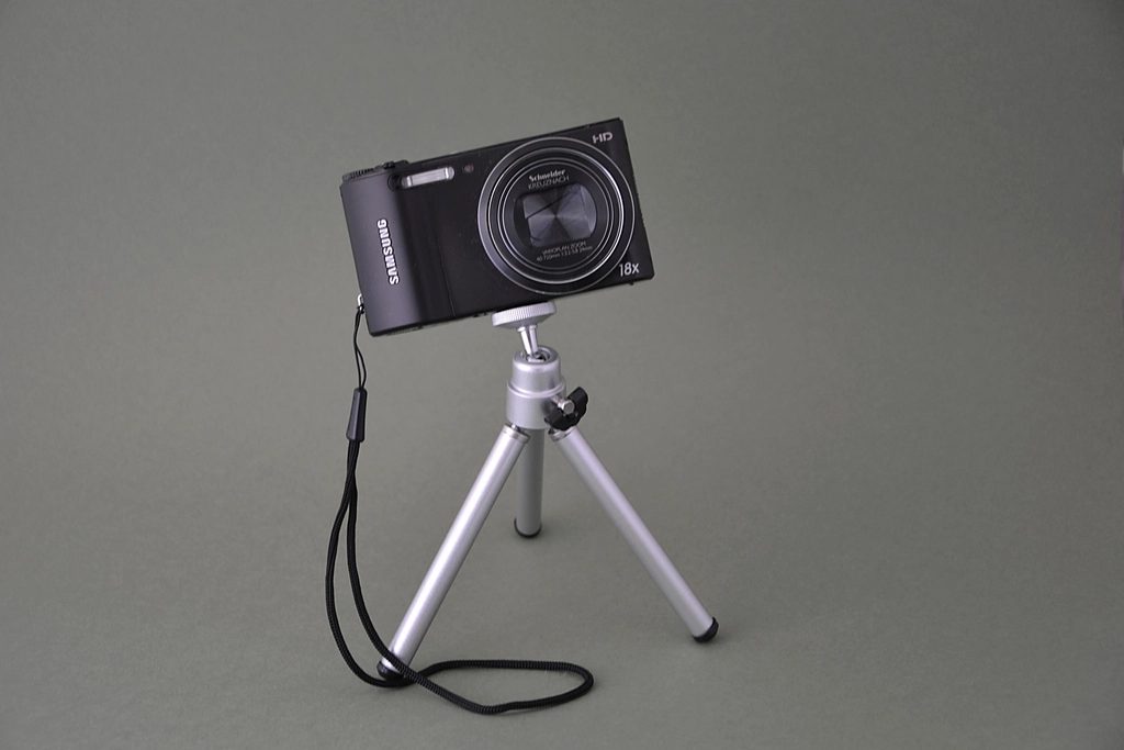 Camera on a tripod set up for a video shoot on a tabletop backdrop.