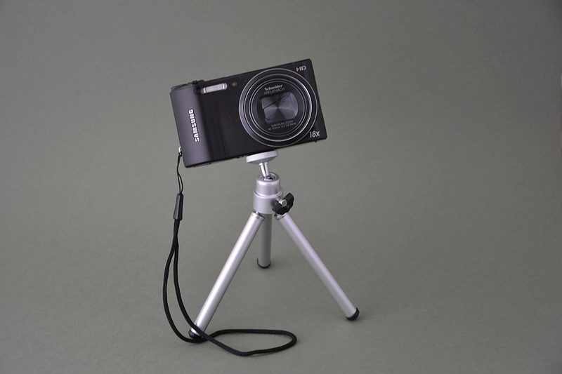 Camera on a tripod set up for a video shoot on a tabletop backdrop.