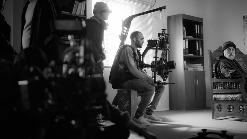 Black and white photo of a film crew working indoors with high-end camera equipment.