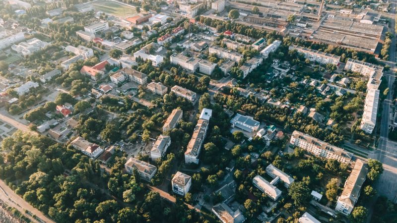 Aerial view of urban cityscape with residential buildings, roads, and greenery.