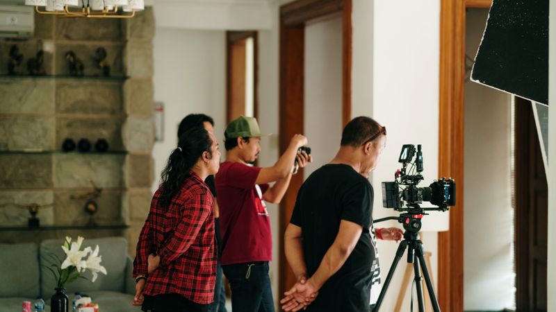 A professional photography crew working inside a studio with camera equipment.