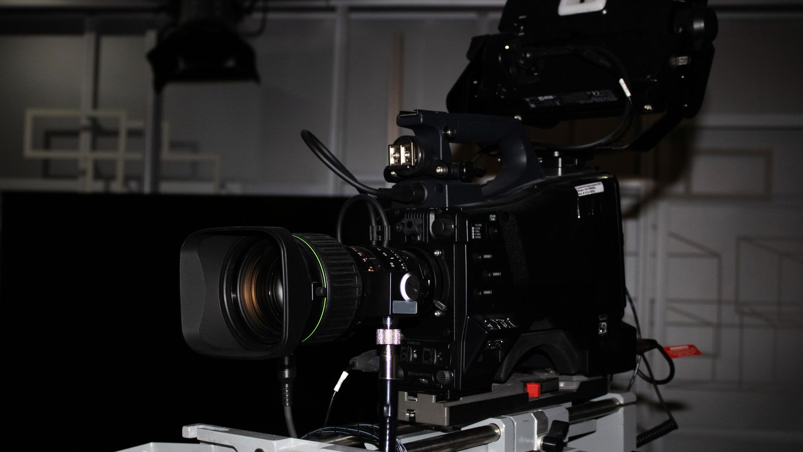 Close-up of a professional video camera rig in a studio environment, highlighting its complexity.