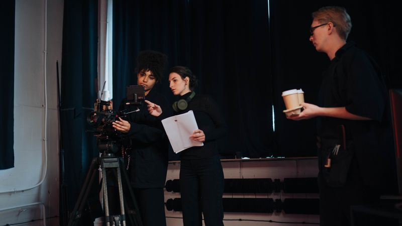 Film crew members collaborating on set, focusing on camera operations and planning.