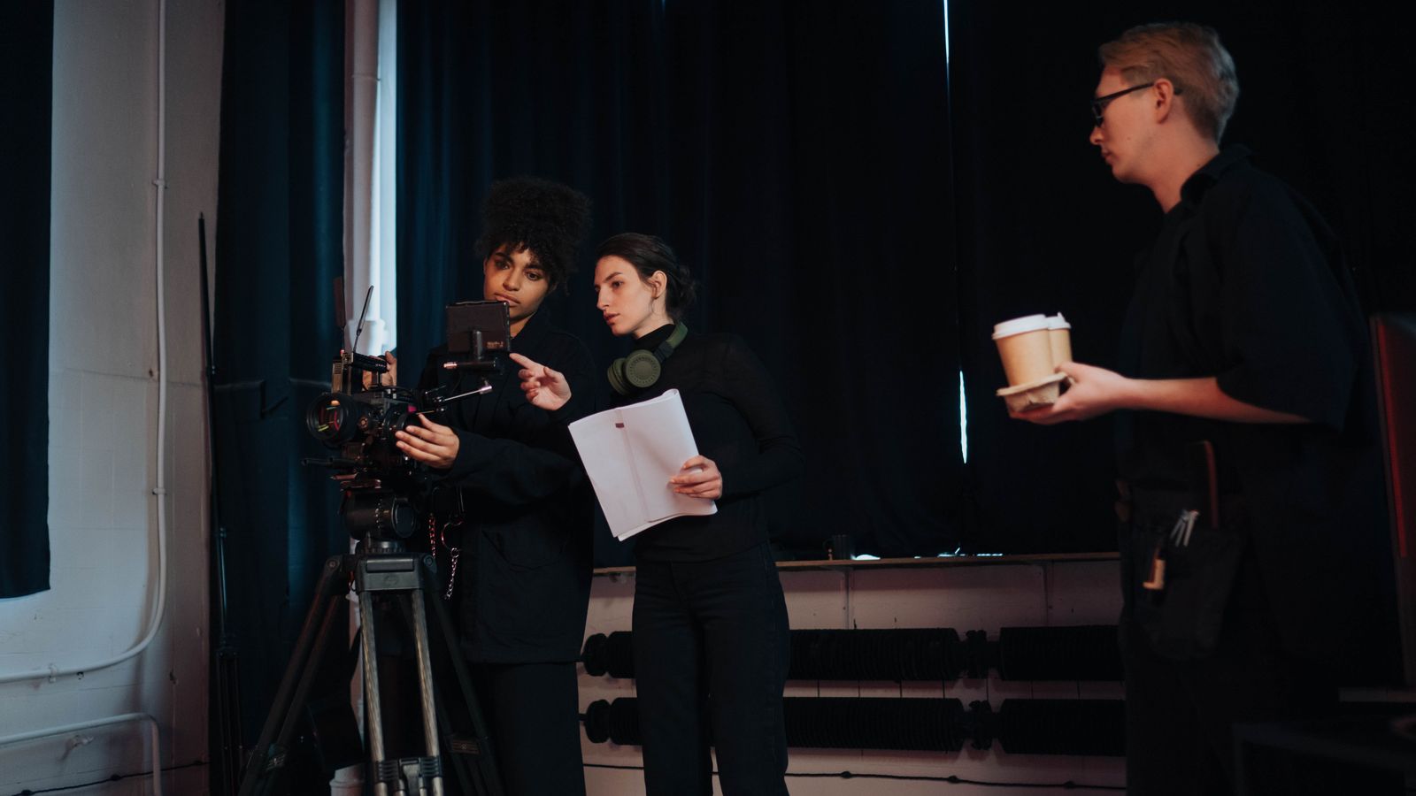 Film crew members collaborating on set, focusing on camera operations and planning.