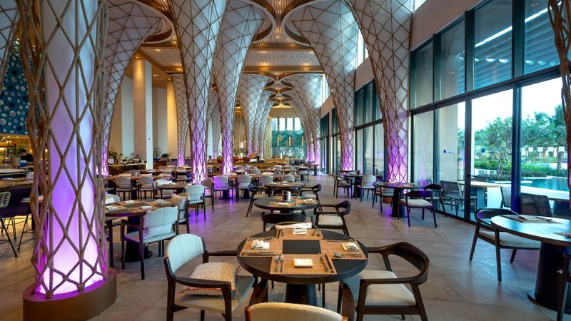 Spacious modern restaurant interior with unique architectural design and ambient lighting.