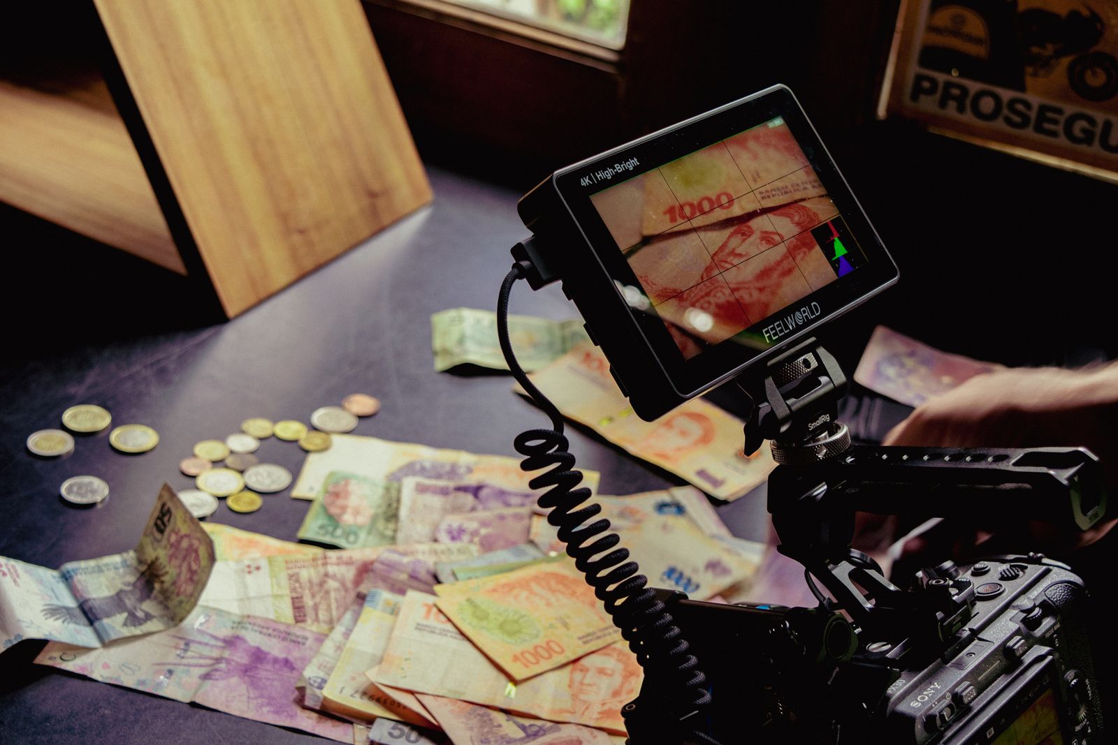 Camera monitor framing banknotes and coins spread on a table