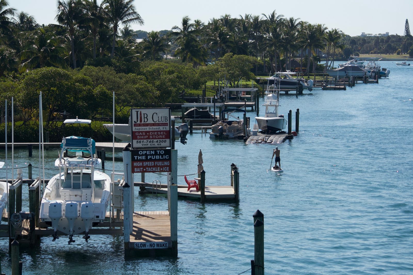 Boats docked along an Intracoastal marina with a red lighthouse in the distance