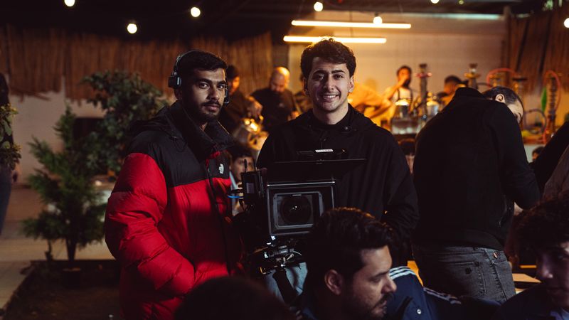 Camera crew capturing a scene indoors with professional equipment in a studio.
