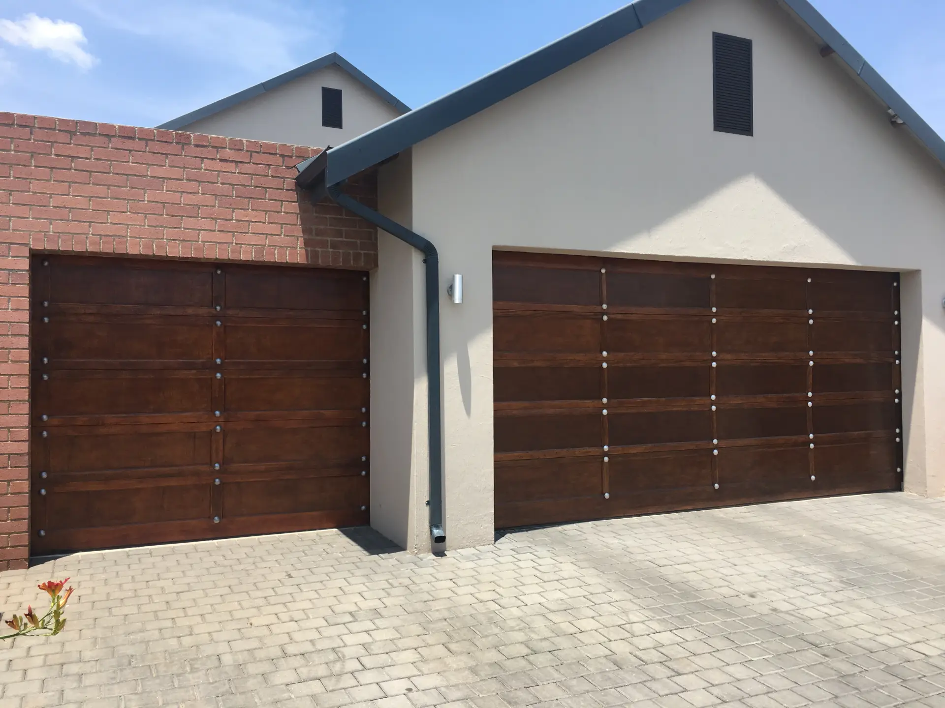 Two wooden garage doors installed on a modern home.