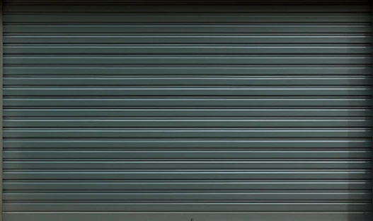 Closed dark grey horizontal aluminum single garage door with consistent panel lines.