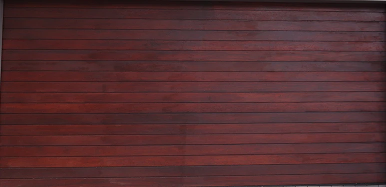 Dark red horizontally slatted wooden garage door with subtle texture.