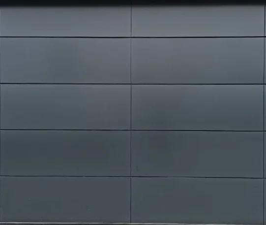 Closed modern dark gray sectional garage door with rectangular panels.