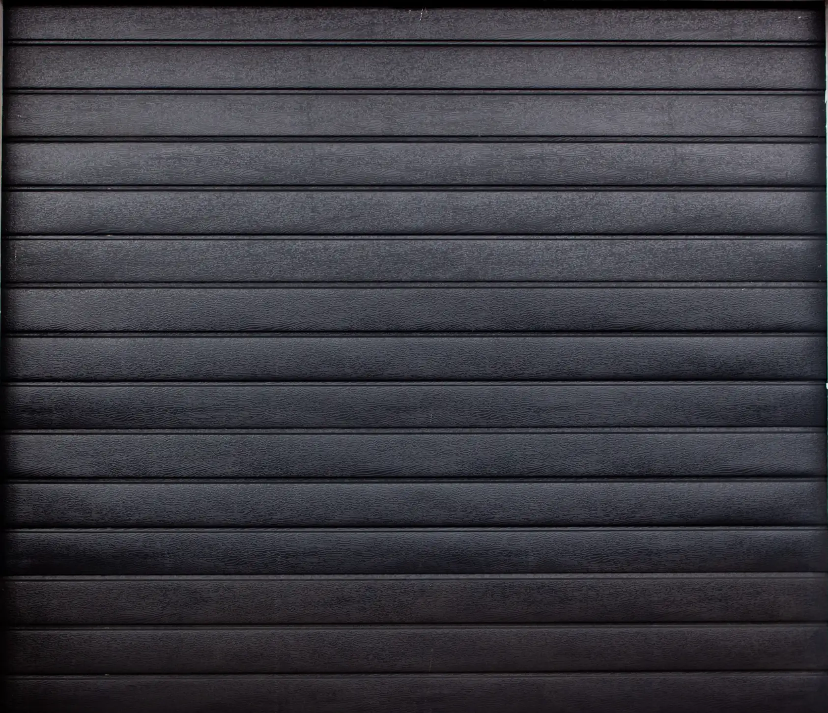 Black horizontal slatted metal or wooden surface with visible texture.