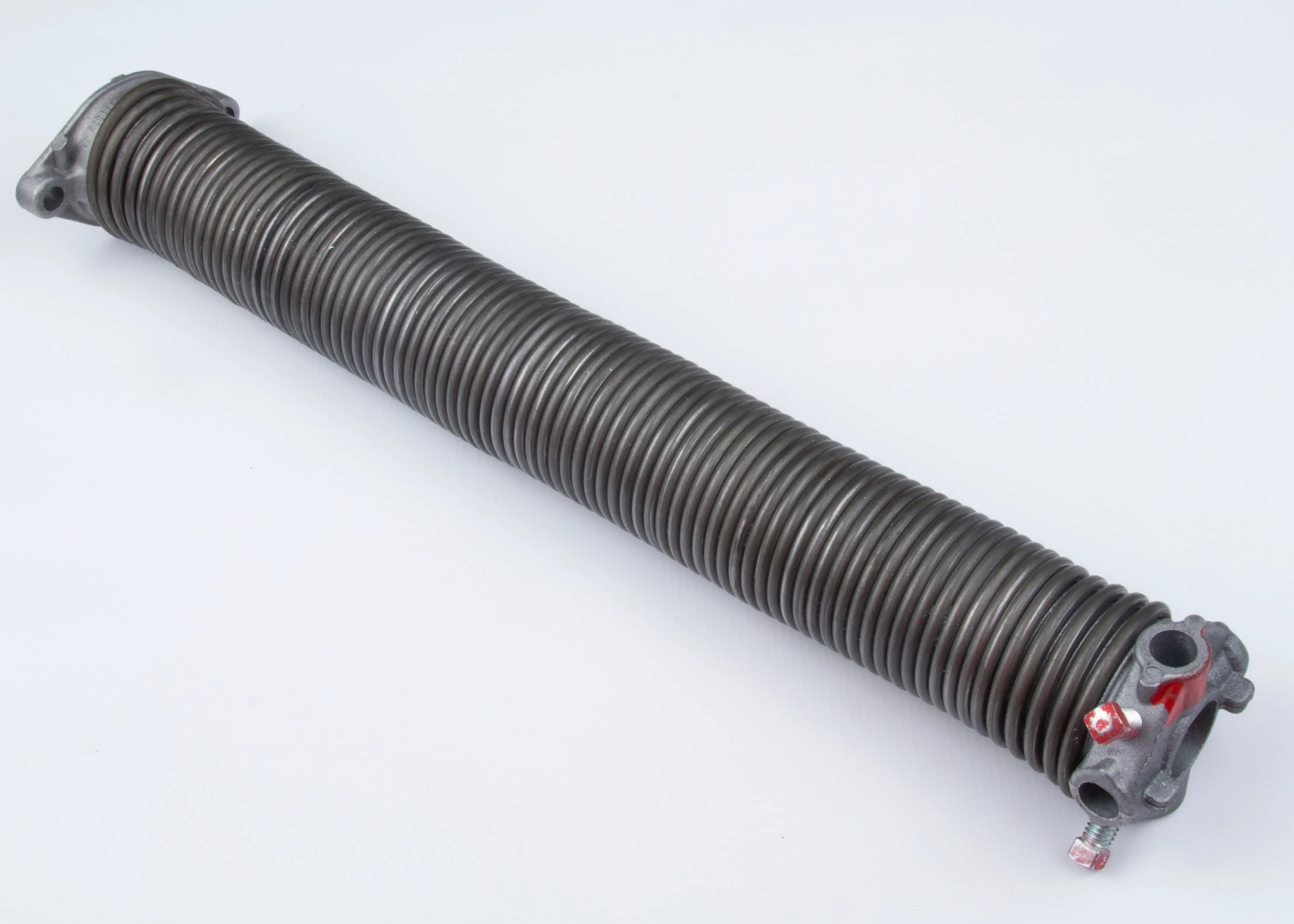 Coiled dark metal torsion spring with mounting brackets on both ends on a white background.