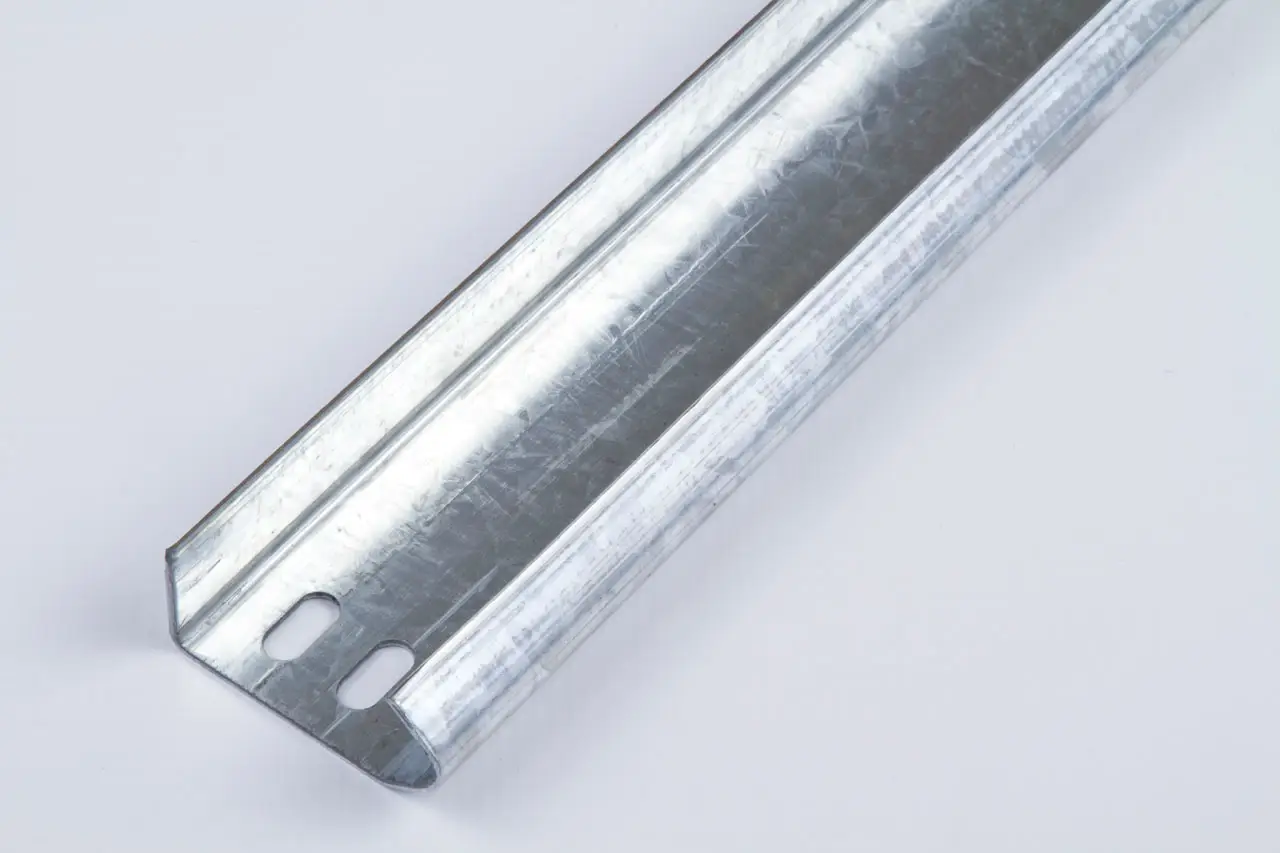 Close-up of a galvanized metal track with two oval holes on a light background.