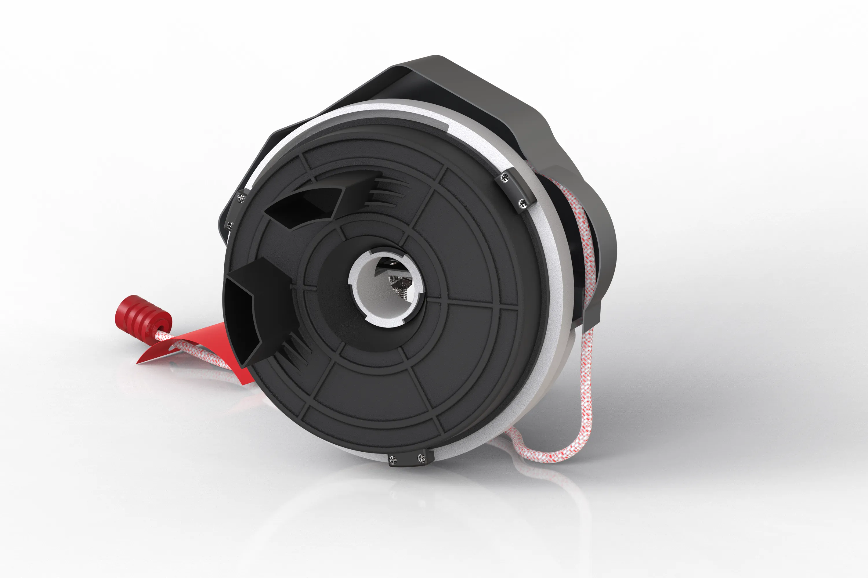 Close-up of a black and silver circular industrial component with a coiled red and white rope attached.