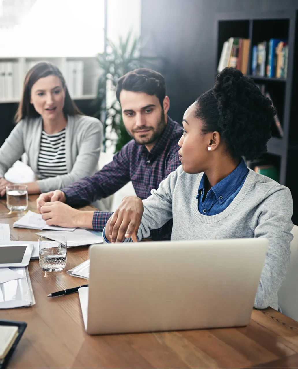 A group of people sitting around a wooden table.