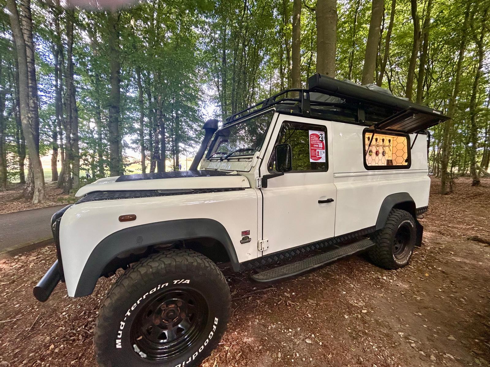white land rover black wheels in woods