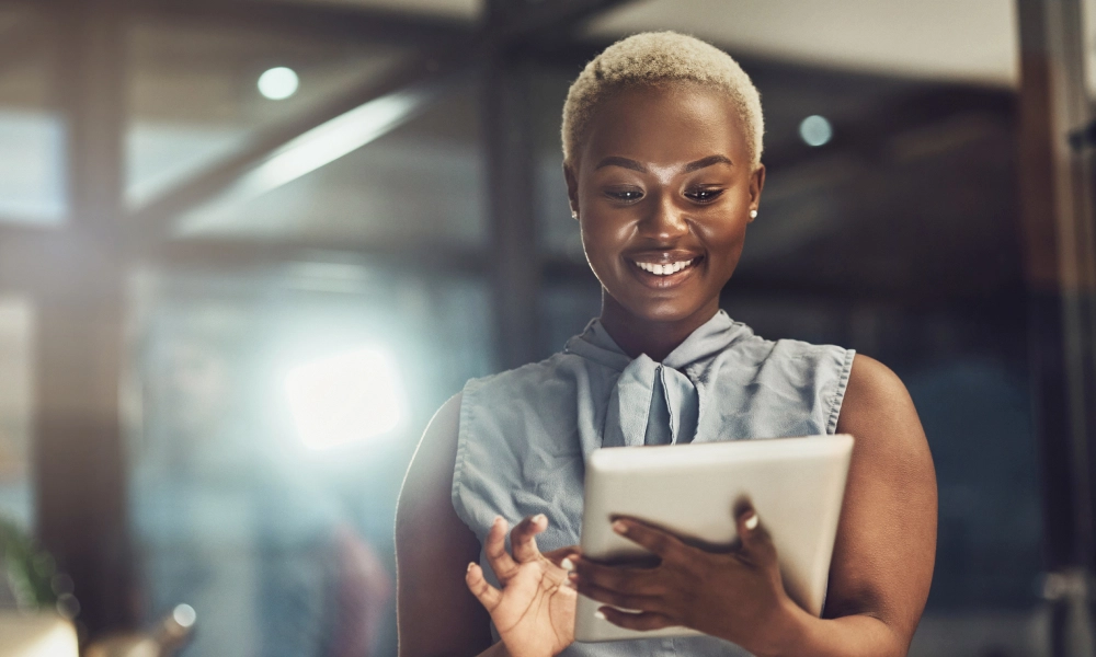 Professional woman smiling while looking at a tablet