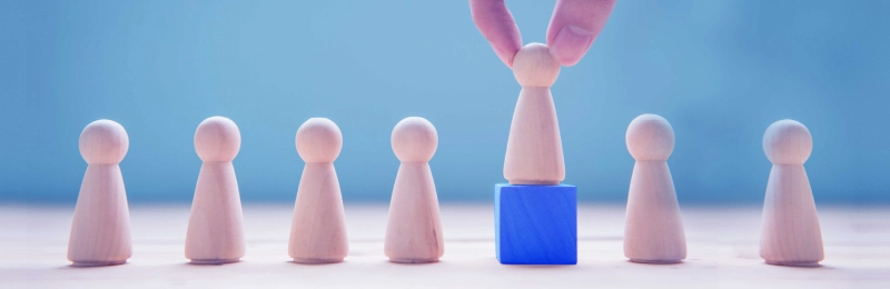 Hand selecting a game piece placed on top of a blue block
