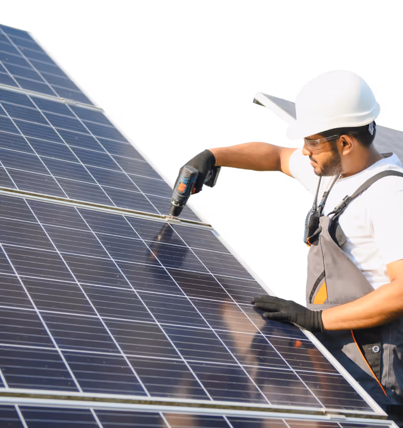 Worker wearing a white hard hat and gloves installing solar panels with a power drill.