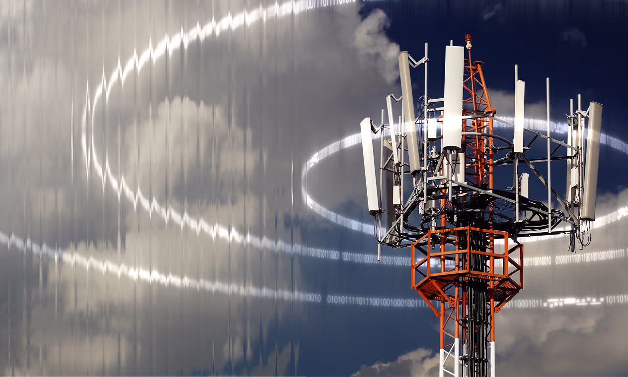 Red and white cellular tower with multiple antennas against a partly cloudy sky and digital signal wave graphics.