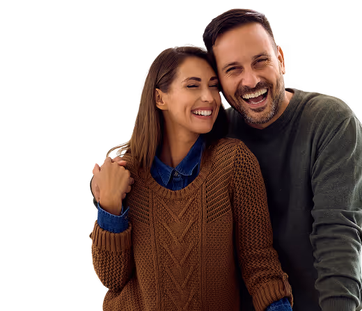 Smiling couple embracing, the woman wearing a brown sweater and the man wearing a gray sweater.