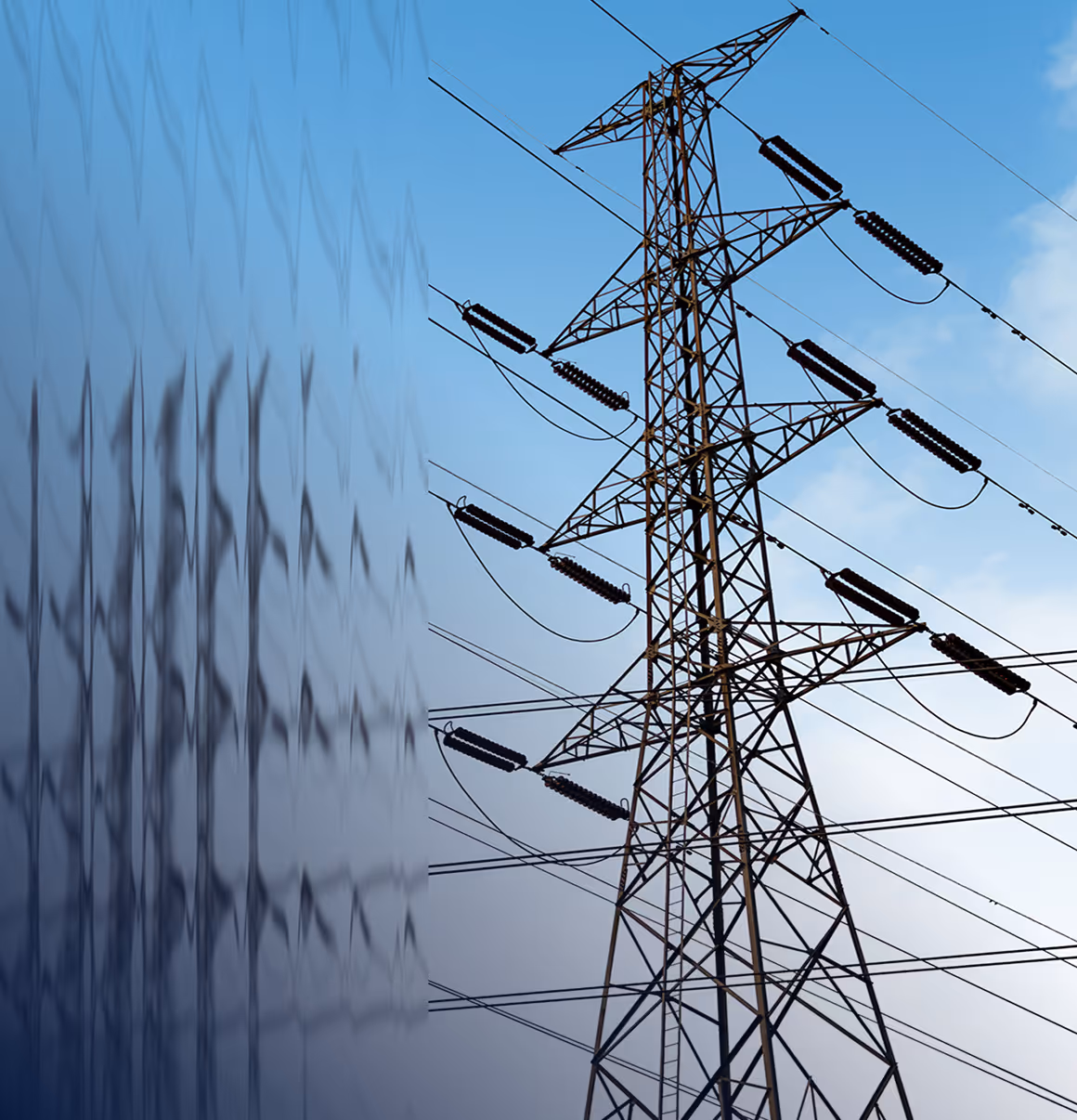 High voltage power transmission tower with insulators and cables reflected on a glass building against a blue sky.
