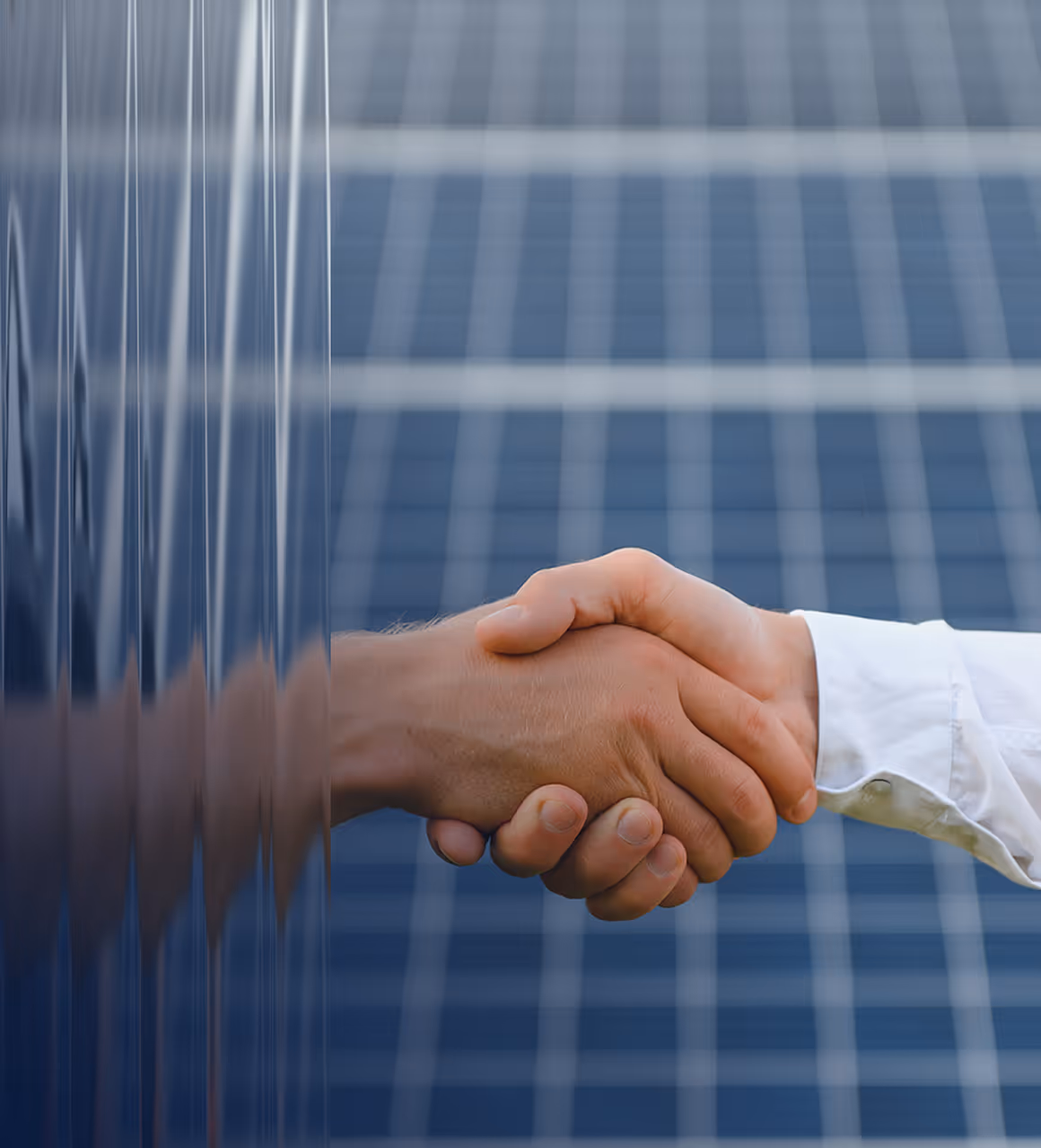 Two people shaking hands with a background of solar panels.
