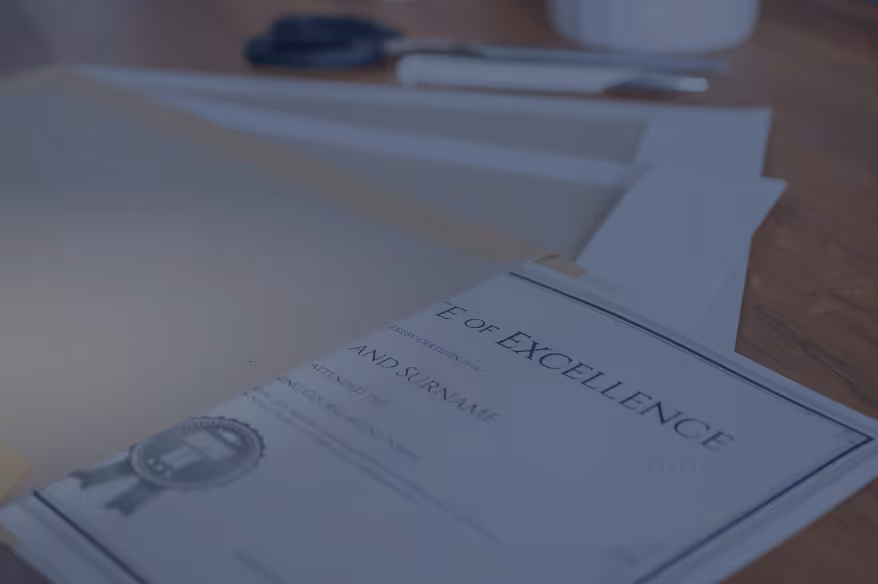 Close-up of a certificate of excellence placed on a wooden surface with blurred office items in the background.
